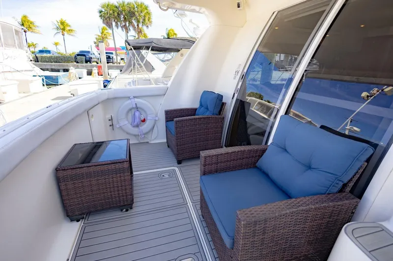 Slide: The Image of 2001 Silverton 410 Sport Bridge yacht deck with wicker chairs and blue cushions. - 35