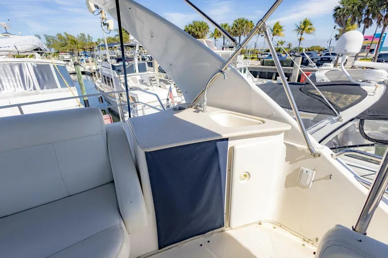 Slide: The Image of 2001 Silverton 410 Sport Bridge yacht interior with seating and sink, docked at marina. - 42