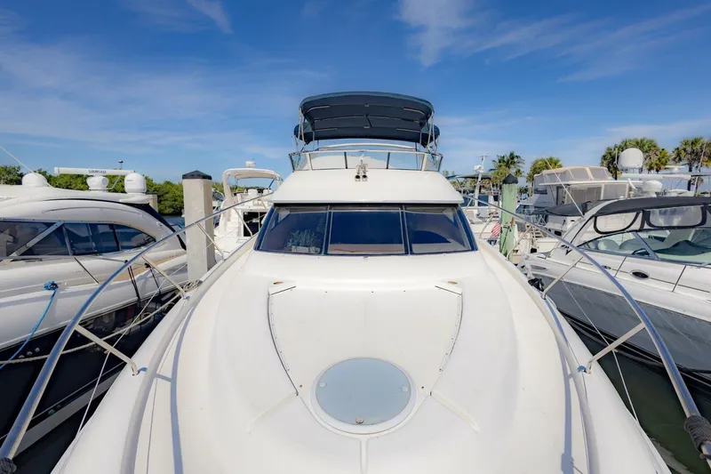 Slide: The Image of 2001 Silverton 410 Sport Bridge yacht docked at marina under clear blue sky. - 44
