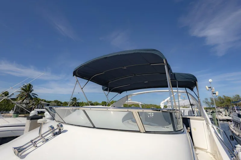 Slide: The Image of 2001 Silverton 410 Sport Bridge yacht with canopy, docked under clear blue sky. - 47