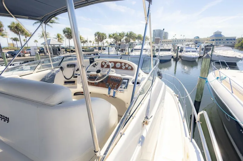 Slide: The Image of 2001 Silverton 410 Sport Bridge yacht at marina, featuring helm and docked boats. - 48