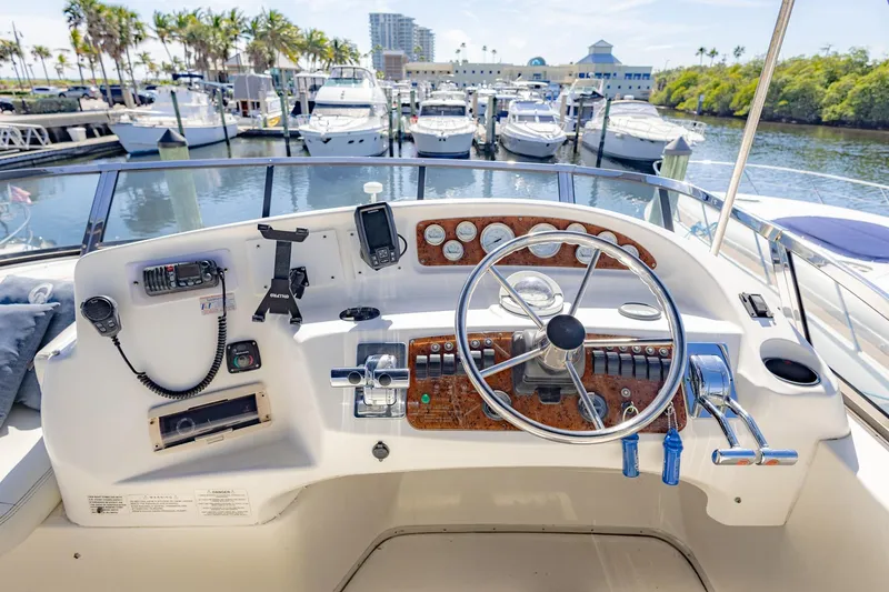 Slide: The Image of Helm of 2001 Silverton 410 Sport Bridge yacht at marina, featuring steering wheel and controls. - 61