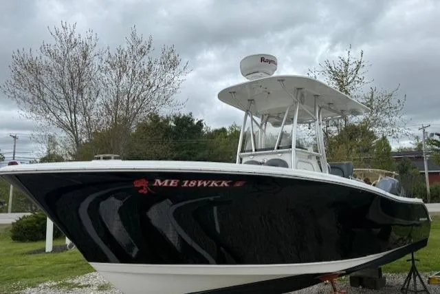 Slide: The Image of 2013 NauticStar 2500XS Offshore boat on display, black hull, overcast sky. - 5