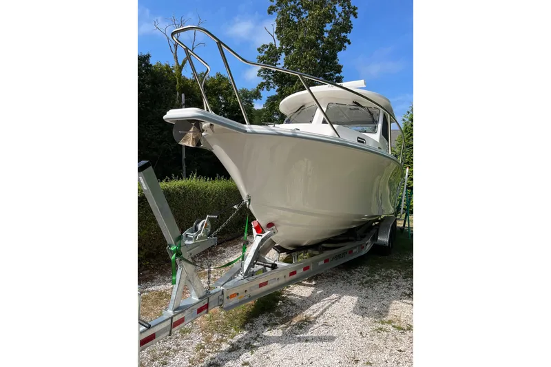 The Image of 2025 NorthCoast 285 HT boat on trailer, parked outdoors, surrounded by greenery. - 0