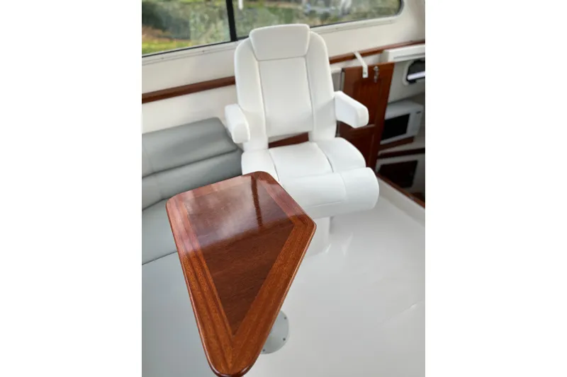 Slide: The Image of Luxurious interior of 2025 NorthCoast 285 HT boat with white seating and wooden table. - 10