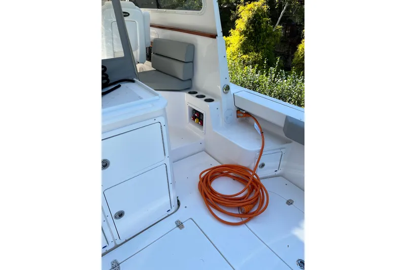 Slide: The Image of Interior of 2025 NorthCoast 285 HT boat with coiled orange cable and seating. - 14