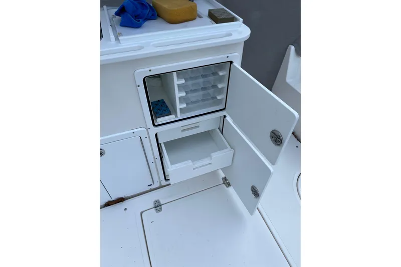 Slide: The Image of Open storage compartment on 2025 NorthCoast 285 HT boat, featuring organized shelves and drawers. - 17