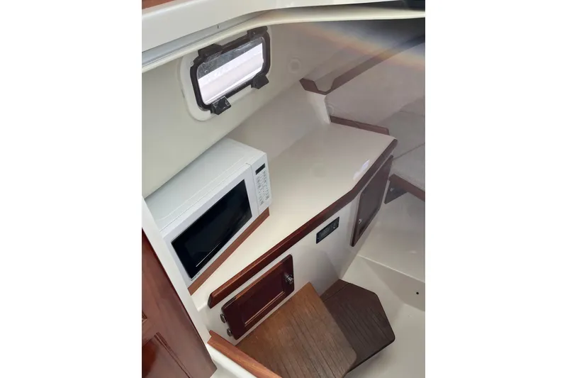 Slide: The Image of 2025 NorthCoast 285 HT cabin interior with microwave and wooden cabinetry. - 24