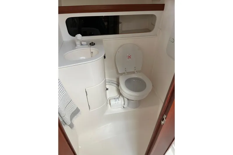 Slide: The Image of 2025 NorthCoast 285 HT boat bathroom with sink, toilet, and mirror. - 31