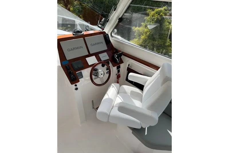 Slide: The Image of 2025 NorthCoast 285 HT helm with dual Garmin displays and white captain's chair. - 4