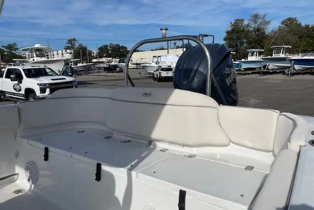 Slide: The Image of 2024 Sea Hunt Ultra 229 boat with spacious seating and powerful engine in a marina setting. - 11