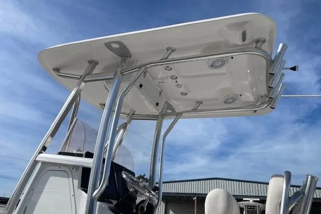 Slide: The Image of 2024 Sea Hunt Ultra 229 boat with T-top and rod holders against blue sky. - 12