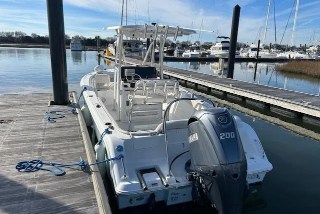 Slide: The Image of 2024 Sea Hunt Ultra 229 boat docked with Yamaha 200 engine, marina background. - 13