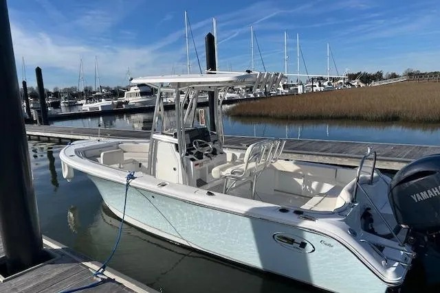 Slide: The Image of 2024 Sea Hunt Ultra 229 boat docked at marina with clear blue sky. - 2
