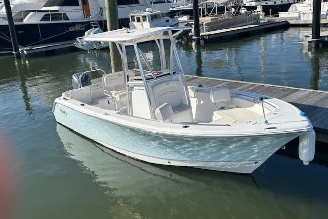 Slide: The Image of 2024 Sea Hunt Ultra 229 boat docked in marina, featuring sleek design and spacious deck. - 5