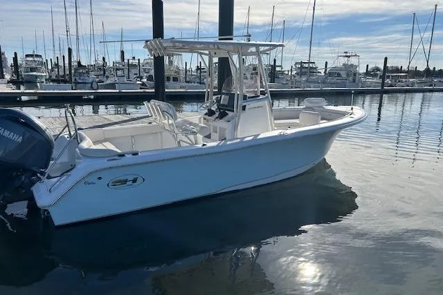 Slide: The Image of 2024 Sea Hunt Ultra 229 boat docked in a marina, featuring sleek design and Yamaha engine. - 7