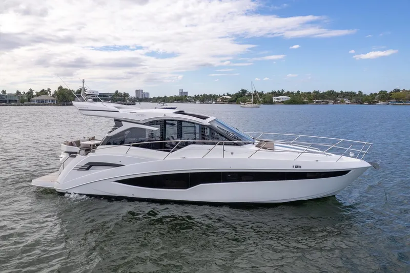 The Image of 2023 Galeon 425 HTS yacht cruising on a calm, scenic waterway. - 0