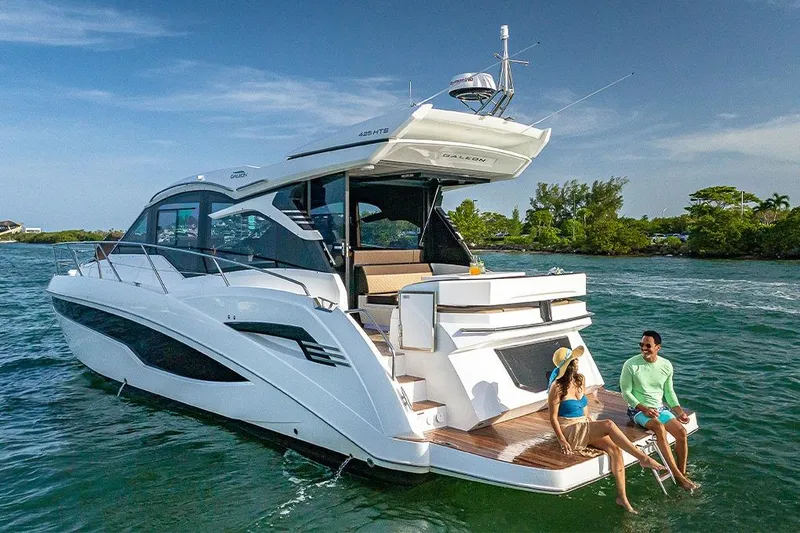Slide: The Image of 2023 Galeon 425 HTS yacht on calm water, rear view showcasing deck and seating area. - 6