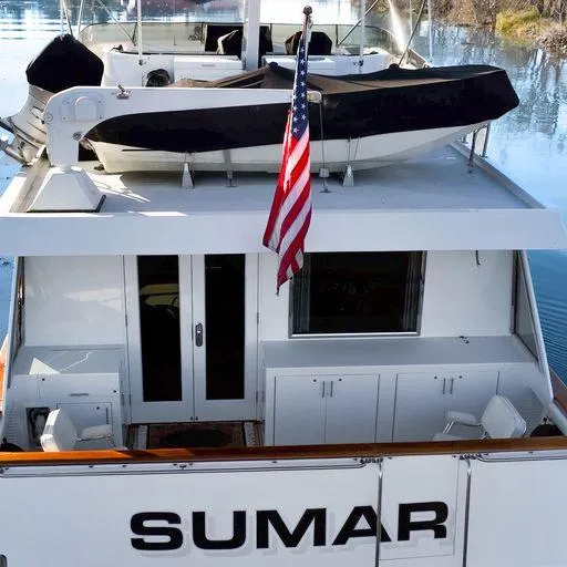 Slide: The Image of Vic Franck 65 Pilot House 1991 yacht SUMAR with American flag and tender boat. - 12