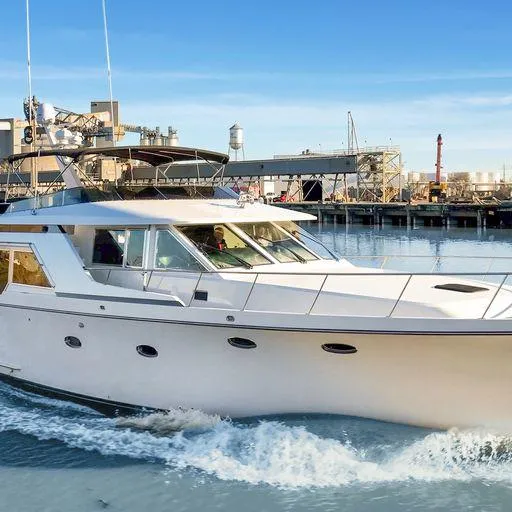 Slide: The Image of Vic Franck 65 Pilot House 1991 yacht cruising near an industrial dock. - 2