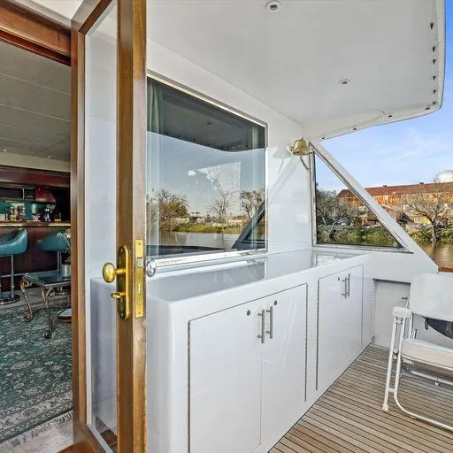 Slide: The Image of Vic Franck 65 Pilot House 1991 yacht interior with open door to deck and seating area. - 22