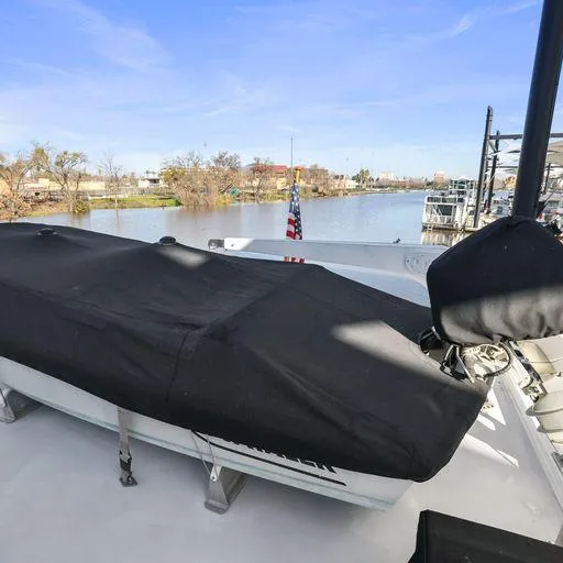 Slide: The Image of Vic Franck 65 Pilot House 1991 yacht deck with covered equipment, docked by a serene river. - 26
