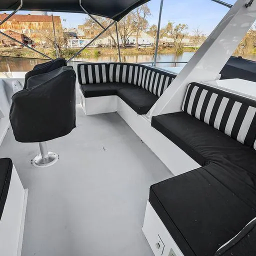 Slide: The Image of Upper deck seating area of a 1991 Vic Franck 65 Pilot House yacht with black and white cushions. - 30