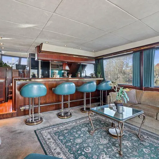 Slide: The Image of 1991 Vic Franck 65 Pilot House interior with bar, teal stools, and large windows. - 33