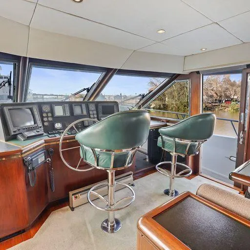 Slide: The Image of 1991 Vic Franck 65 Pilot House interior with helm and green captain chairs. - 43