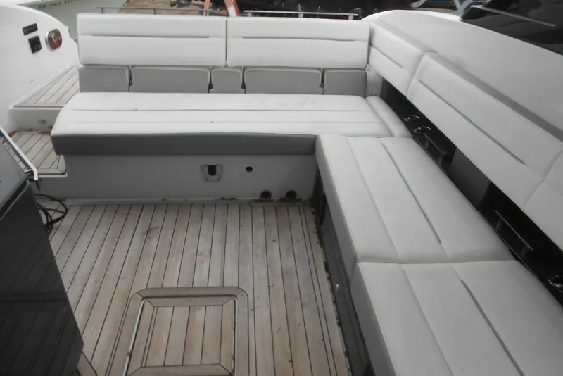 Slide: The Image of 2020 Cobalt A36BR boat interior with white cushioned seating and wooden deck. - 44