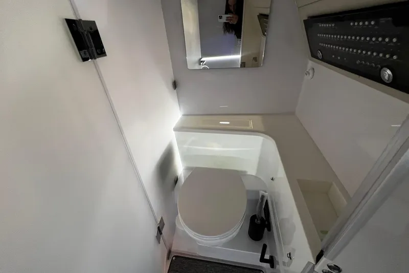 Slide: The Image of 2026 Axopar 37 XC Cross Cabin bathroom interior with modern fixtures and mirror. - 12