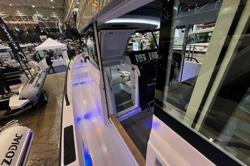Slide: The Image of 2026 Axopar 37 XC Cross Cabin interior at a boat show, featuring modern controls and lighting. - 27