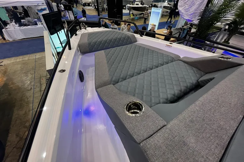 Slide: The Image of 2026 Axopar 37 XC Cross Cabin with luxurious seating and modern design at a boat show. - 3