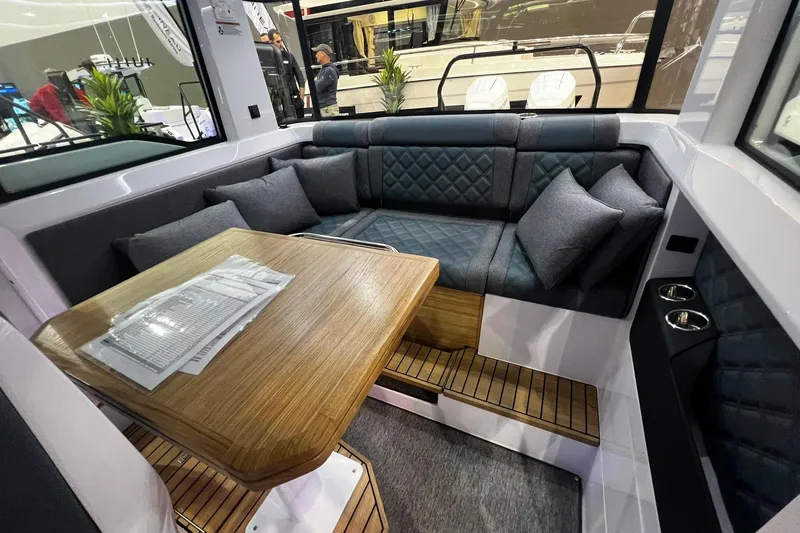 Slide: The Image of 2026 Axopar 37 XC Cross Cabin interior with cozy seating and wooden table. - 31