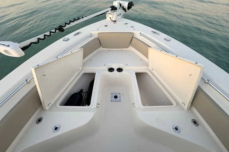 Slide: The Image of 2023 Key West 219 FS boat deck with open storage compartments on calm water. - 18