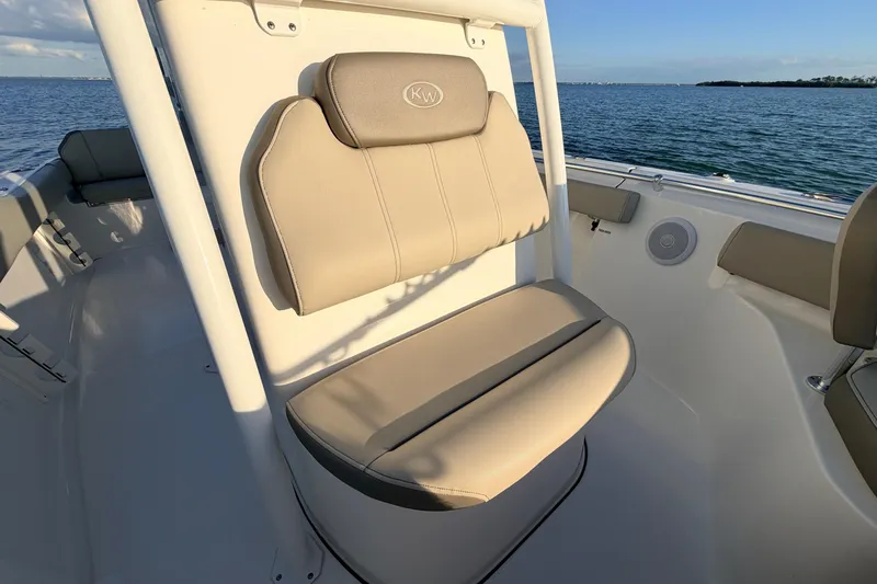 Slide: The Image of 2023 Key West 219 FS boat seat with beige upholstery, ocean view in background. - 22