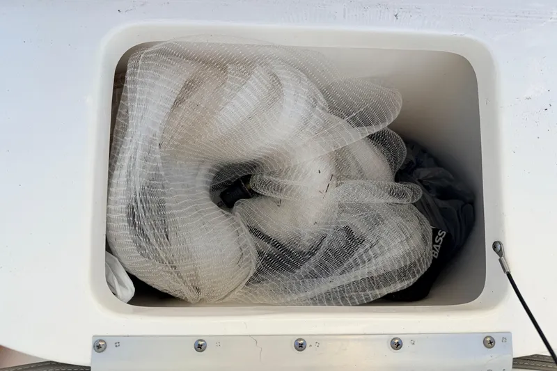 Slide: The Image of Storage compartment on 2023 Key West 219 FS boat with fishing net inside. - 24