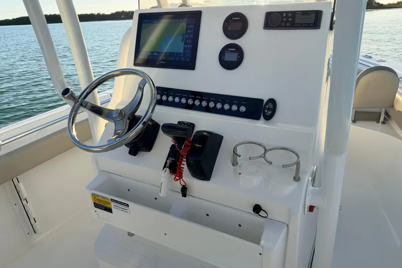 Slide: The Image of 2023 Key West 219 FS boat dashboard with steering wheel and navigation controls. - 25