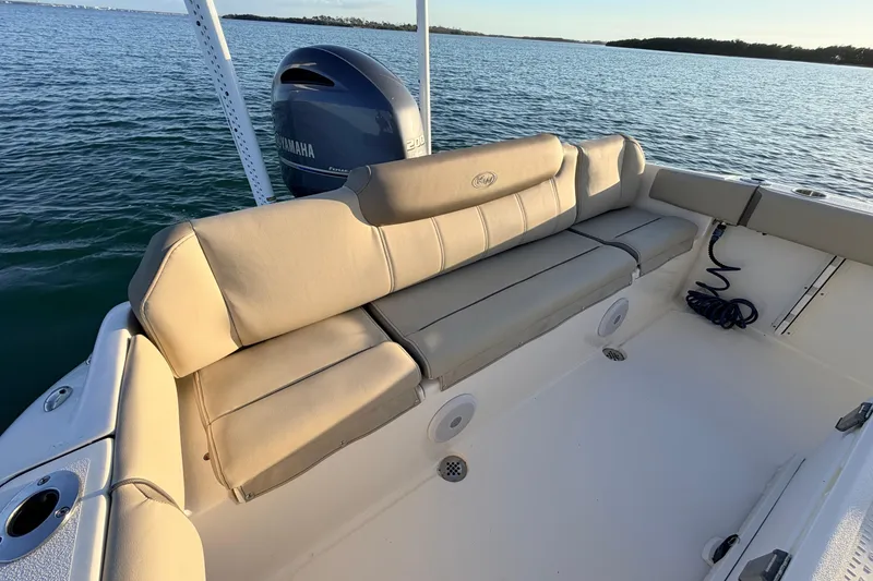 Slide: The Image of 2023 Key West 219 FS boat interior with Yamaha engine, beige seating, and ocean backdrop. - 43