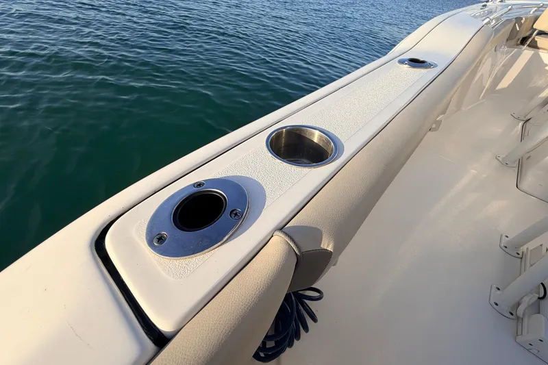 Slide: The Image of 2023 Key West 219 FS boat deck with cup holders and rod holder by the water. - 47