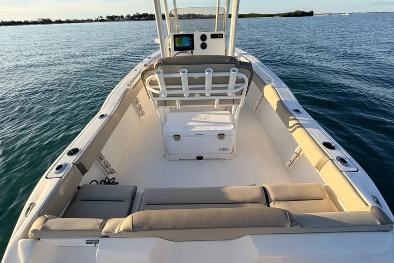 Slide: The Image of 2023 Key West 219 FS boat interior with seating and cooler on calm water. - 57