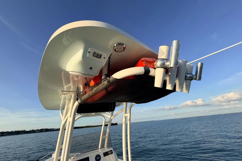 Slide: The Image of 2023 Key West 219 FS boat with rod holders and canopy on calm water. - 60