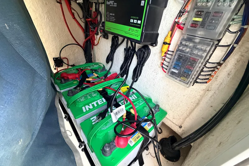 Slide: The Image of 2023 Key West 219 FS boat battery compartment with wiring and fuse panel. - 65