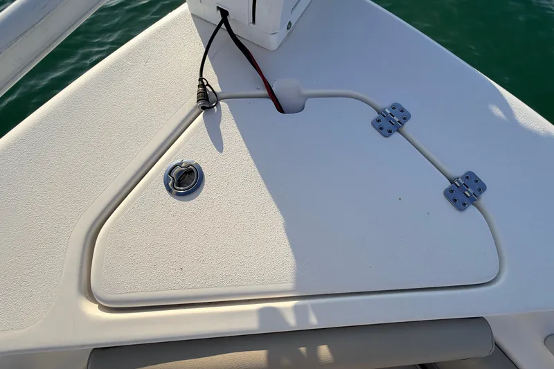 Slide: The Image of 2023 Key West 219 FS boat deck with hatch and hinges, on calm water. - 7