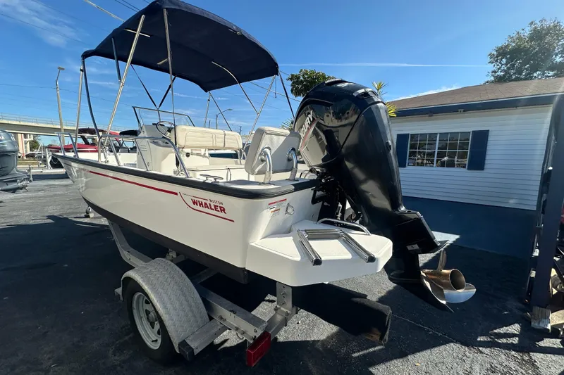 Slide: The Image of 2021 Boston Whaler 170 Montauk boat on trailer with outboard motor and canopy. - 4