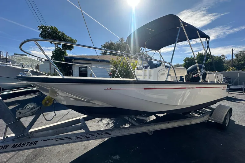 Slide: The Image of 2021 Boston Whaler 170 Montauk boat on trailer under sunny sky. - 5