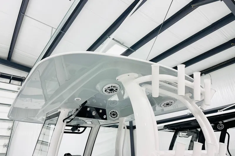 Slide: The Image of 2026 Sportsman Open 302 Center Console boat with T-top and rod holders in a showroom. - 7