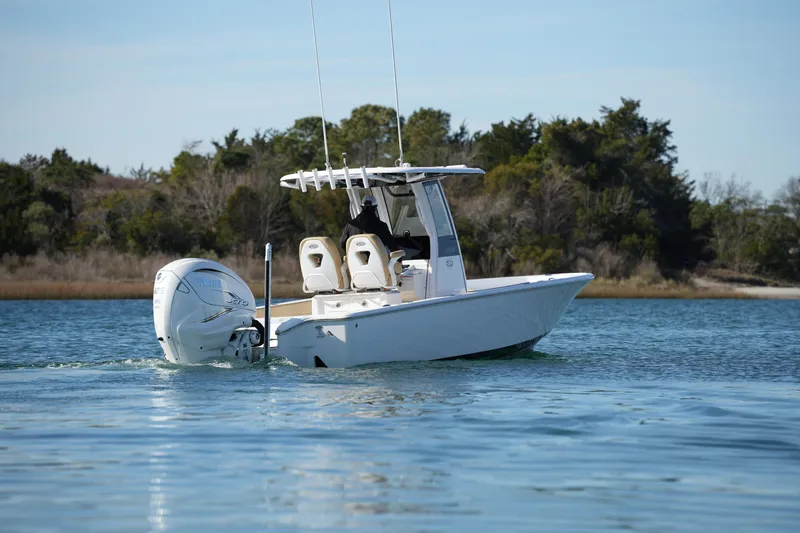 Slide: The Image of 2023 Sportsman Masters 267 Bay Boat cruising on calm water near shoreline. - 16