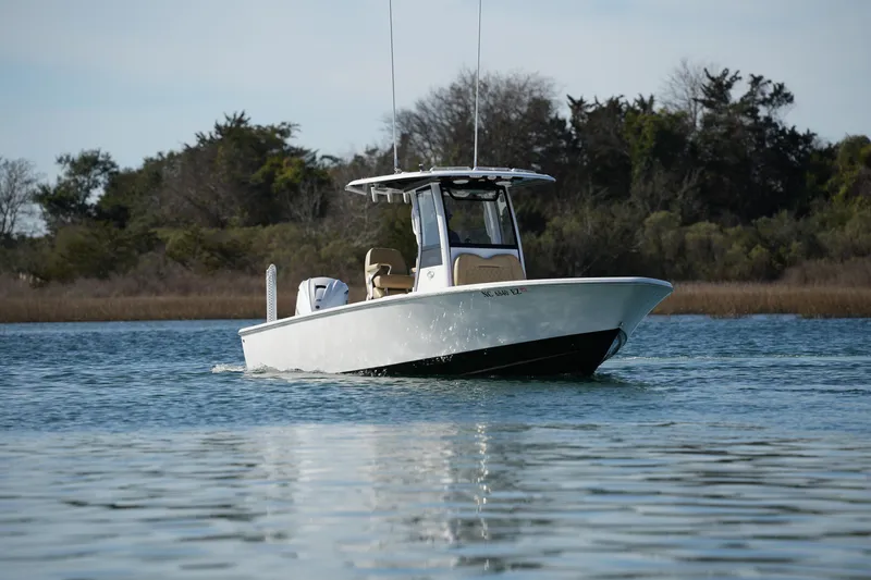 Slide: The Image of 2023 Sportsman Masters 267 Bay Boat cruising on calm water near shoreline. - 2