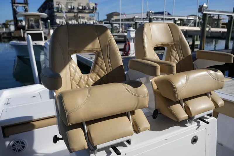 Slide: The Image of 2023 Sportsman Masters 267 Bay Boat with luxurious tan leather seats at a marina. - 25